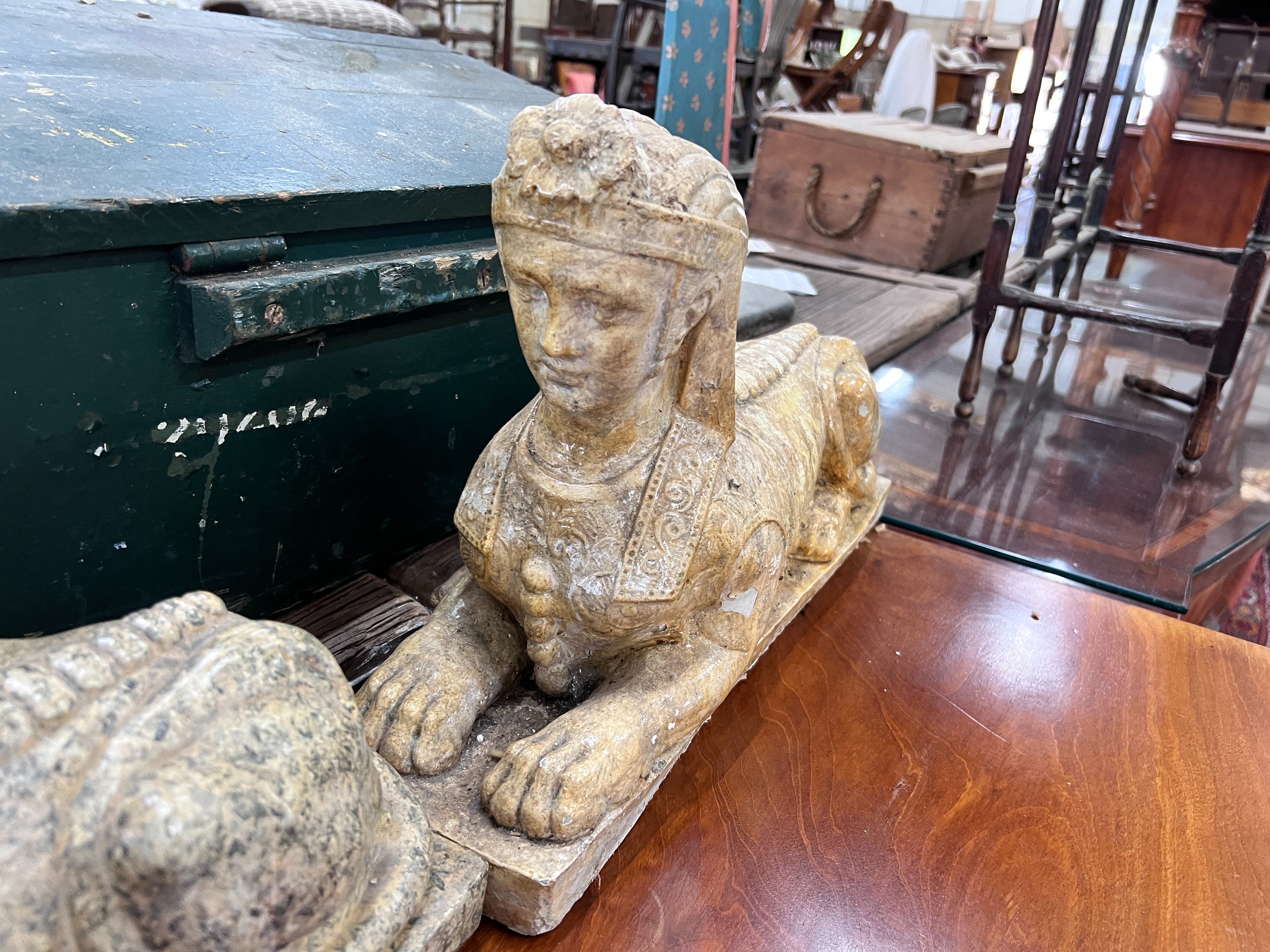 A pair of composition faux marble sphinx, length 48cm, height 30cm *Please note the sale commences at 9am.